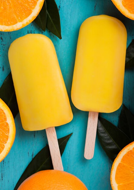 Gelato arancio della frutta organica fresca con le foglie con le arance fresche su fondo di legno blu.