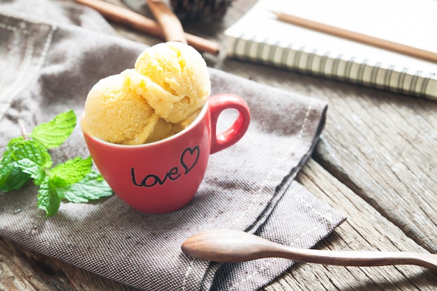 Gelato casalingo del mango in ciotola ceramica sulla tavola di legno rustica