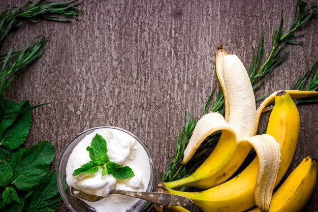 Gelato con banana fresca e menta su tavola di legno