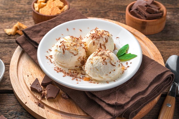 Gelato cremoso con gocce di cioccolato e biscotti su fondo di legno. Vista laterale, primo piano. Dessert estivo.Vista laterale, primo piano. Dolce estivo.