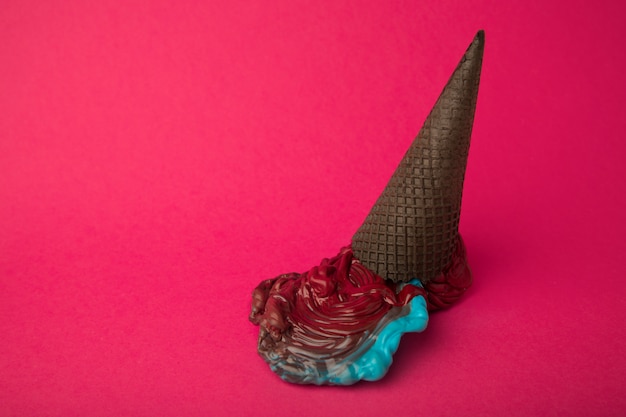 Gelato di plastica blu e rosso in cono nero cioccolato sul rosa