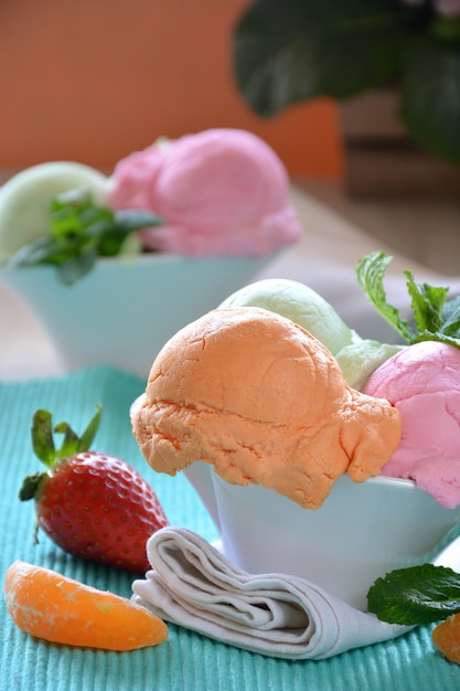 Gelato di vari gusti, accompagnato da menta, mandarino e fragole