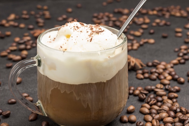 Gelato e vetro con caffè. Chicchi di caffè sparsi sul tavolo.