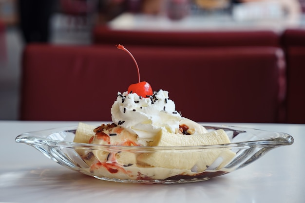 Gelato in un piatto da barca decorato con banana e ciliegia.