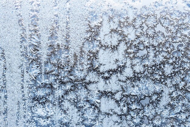 Gelo blu sulla superficie sul primo piano di vetro della finestra domestica