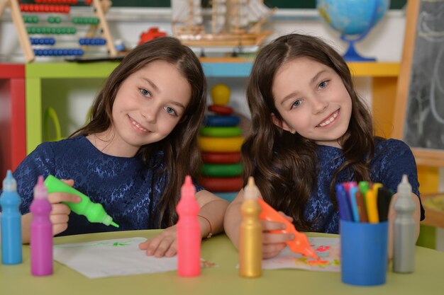 Gemelle studentesse carine durante una lezione d'arte a scuola