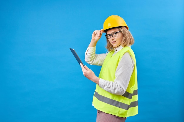 Generatore di donna d'affari che lavora con tablet PC Donna sorridente in studio su sfondo blu Il concetto di decorazione di riparazione di costruzione Riprese in studio