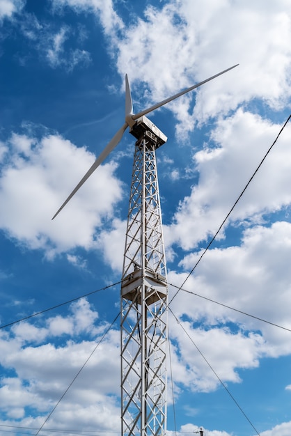 Generatore eolico su uno sfondo di cielo azzurro con nuvole