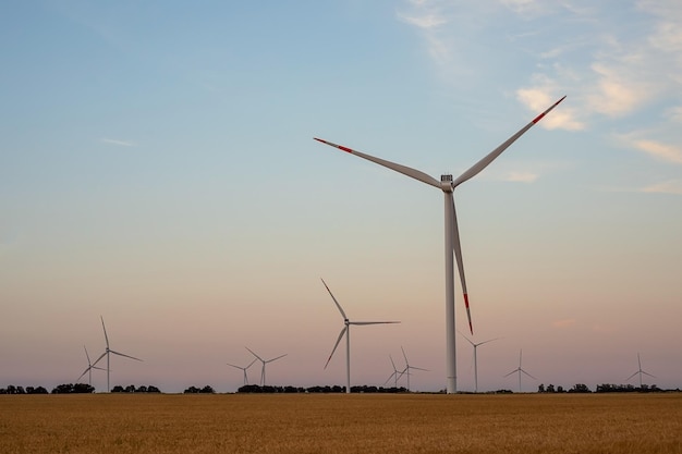 Generatori di generatori di turbine eoliche mulini a vento sullo sfondo del paesaggio al tramonto