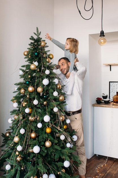 Generi con la figlia vicino all'albero di Natale su natale a casa