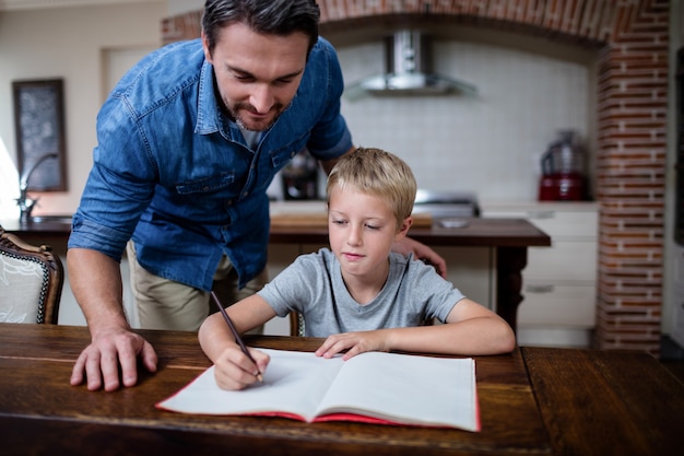 Generi il figlio d'aiuto con i suoi compiti in cucina