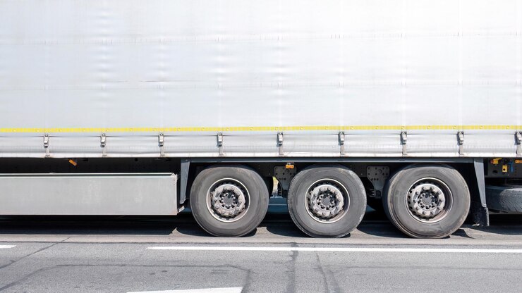 Generico semplice trasporto commerciale camion rimorchio vista laterale dettaglio ruote primo piano sfondo semplice con spazio di copia Logistica azienda merci trasporto economia d'affari concetto finanziario sfondo