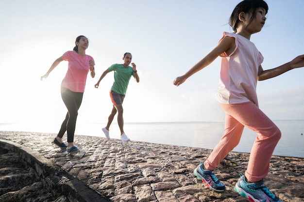 Genitore asiatico e bambini che praticano sport all'aperto