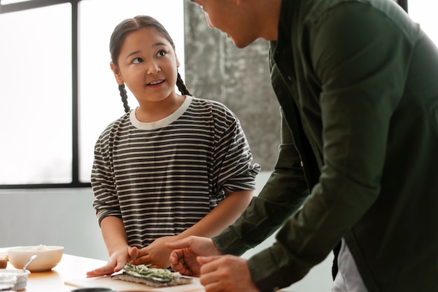 Genitore che insegna al figlio a fare il sushi