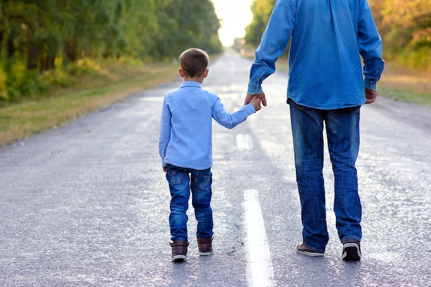 genitore con un bambino tiene per mano sulla strada