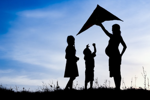 Genitore felice con bambini che giocano sulla silhouette estate natura