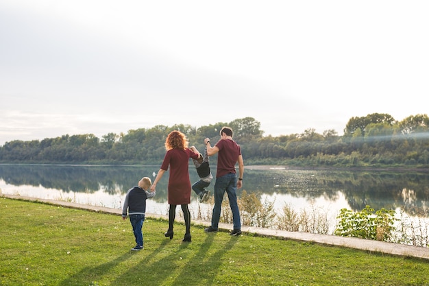 Genitore, infanzia e concetto di natura - Famiglia che gioca con due figli sull'acqua.