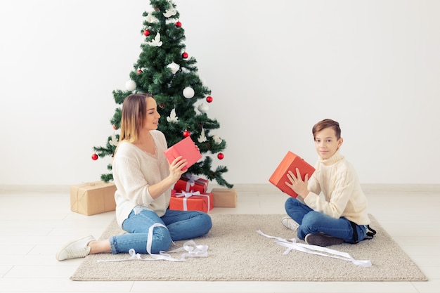 Genitore single e concetto di vacanze - Ritratto di madre e figlio che celebrano il natale a casa la vigilia di natale