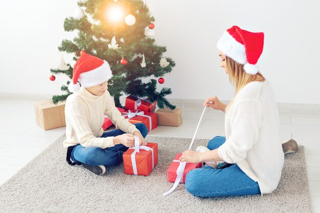 Genitore single e concetto di vacanze - Ritratto di madre e figlio che celebrano il natale a casa la vigilia di natale