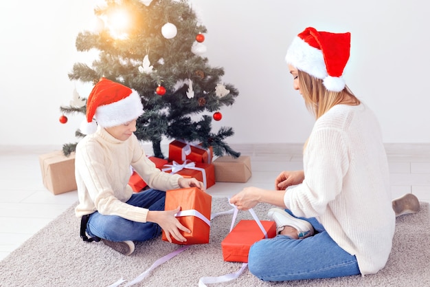 Genitore single e concetto di vacanze - Ritratto di madre e figlio che celebrano il natale a casa la vigilia di natale