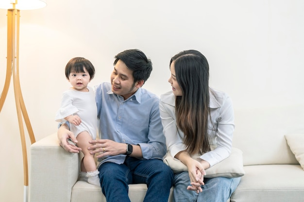 Genitori asiatici e un bambino che gioca in casa. Concetto di famiglia.