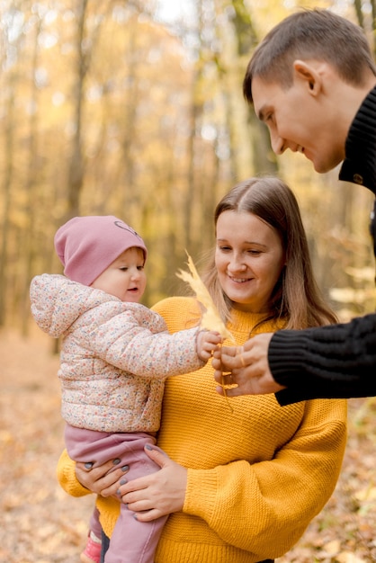 Genitori con figlia che giocano nella foresta autunnale