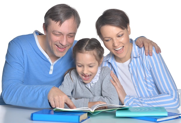 Genitori con figlia che leggono libri contro il bianco