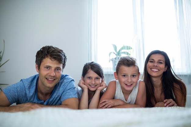 genitori e bambini che giacciono in camera da letto