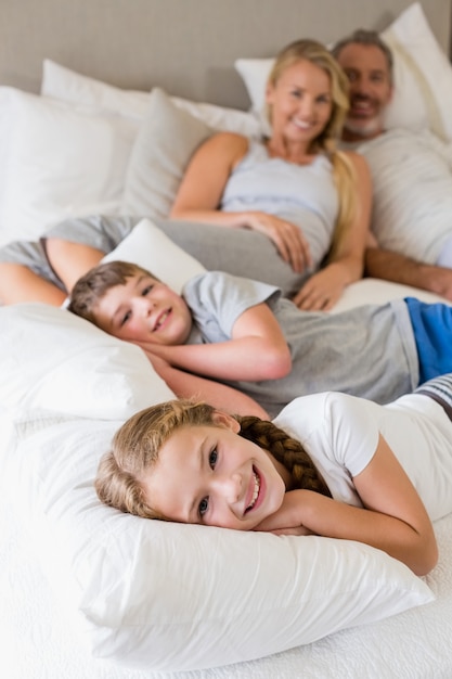 Genitori e bambini che si rilassano sul letto in camera da letto