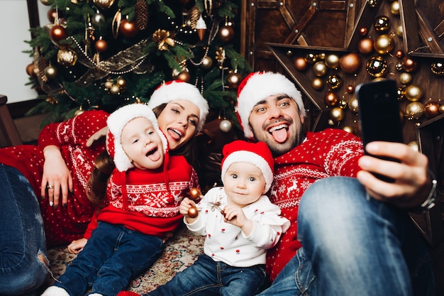 Genitori e figli che prendono selfie a Chrisrmas