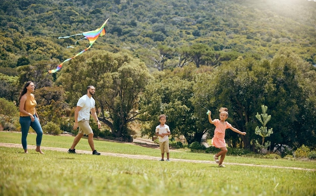 Genitori e figli di aquiloni sono felici nella natura e giocano insieme nel tempo di qualità durante il fine settimana e in vacanza Madre e padre di famiglia con la felicità o il divertimento dei bambini con la gioia o l'estate del giocattolo volante