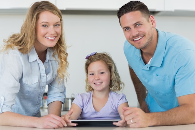 Genitori e ragazza carina utilizzando la tavoletta digitale