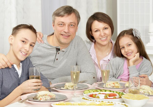 Genitori felici con i loro figli che mangiano