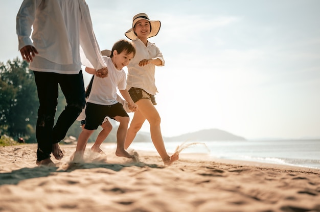 Genitori felici e bambini che si divertono giocando a sabbia durante le vacanze estive sulla spiaggiaViaggi