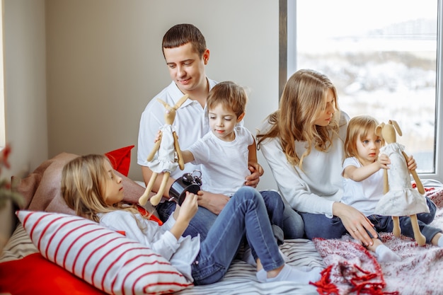 Genitori felici e bambini che si godono la loro mattina a letto