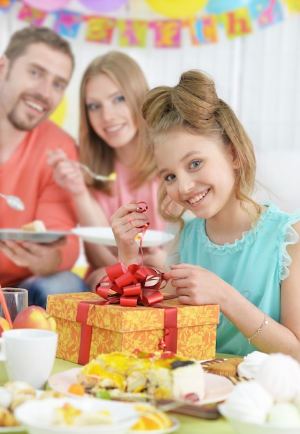 Genitori felici e figlia con la torta alla festa di compleanno