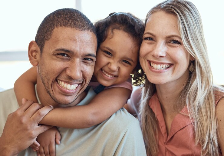 Foto genitori multiculturali ritratto di bambino sul divano e mamma e papà felici sorridono insieme a casa mentre legano l'amore uomo nero donna e figlia ragazza con diversità rilassarsi e abbracciarsi sul divano in casa