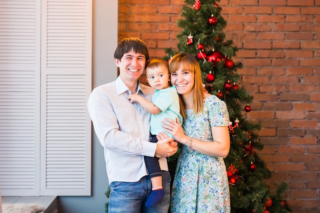 Genitori sorridenti felici e bambino a casa per celebrare il Natale