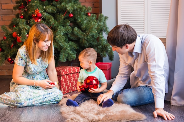 Genitori sorridenti felici e bambino a casa per celebrare il Natale