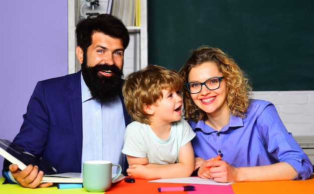 genitorialità. I genitori aiutano il figlio a fare i compiti per la scuola. Studente elementare. Mentoring, insegnamento, concetto di educazione.