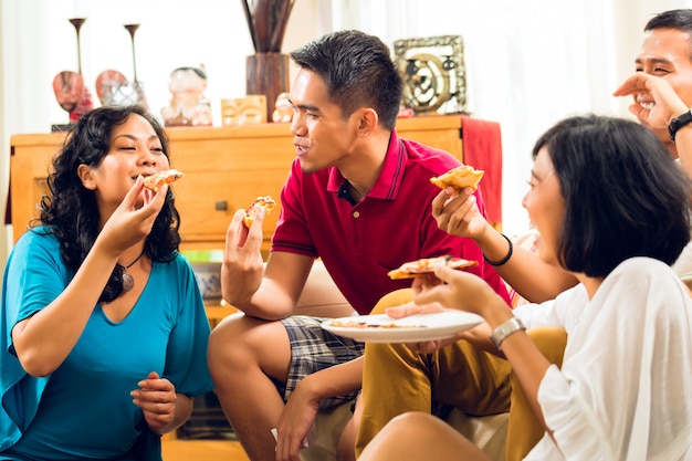 Gente asiatica che mangia pizza alla festa