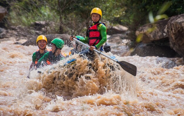 Gente asiatica in azione durante l&#39;avventura di rafting