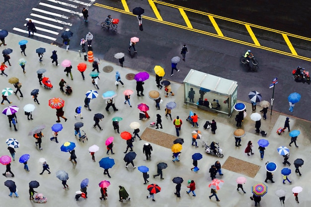 Gente che cammina con gli ombrelli sulla strada