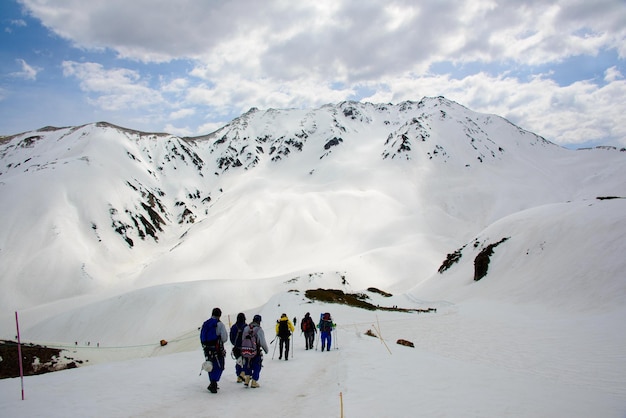 Gente che cammina su una montagna innevata contro il cielo