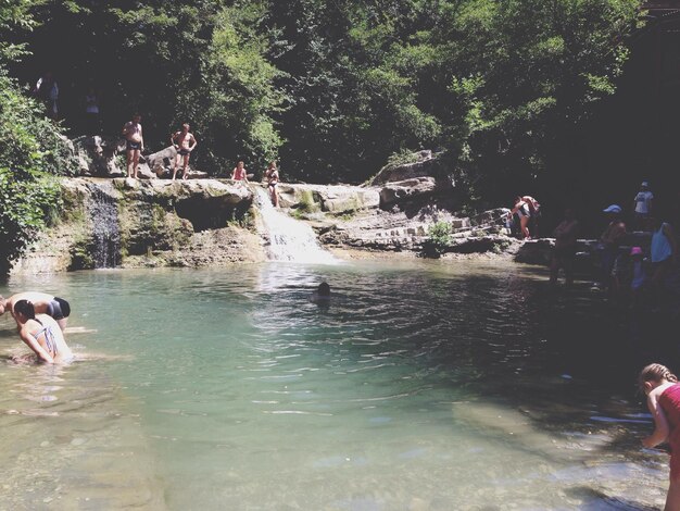 Gente che si diverte al fiume nella foresta durante una giornata di sole