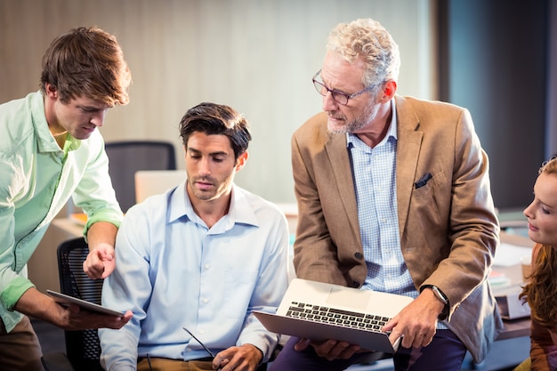 Gente di affari che discute sopra la compressa digitale