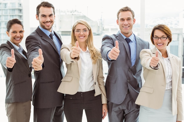 Gente di affari che gesturing i pollici su nell&#39;ufficio