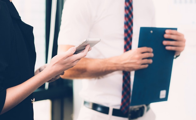 Gente di affari che incontra smartphone della holding della mano.