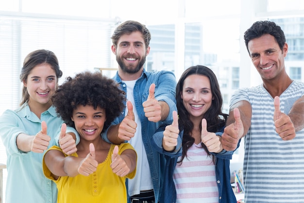 Gente di affari creativa che gesturing i pollici su dalla lavagna