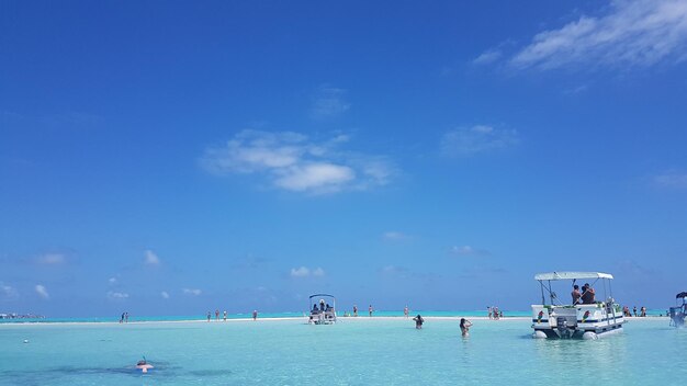 Gente su barche in mare contro il cielo blu